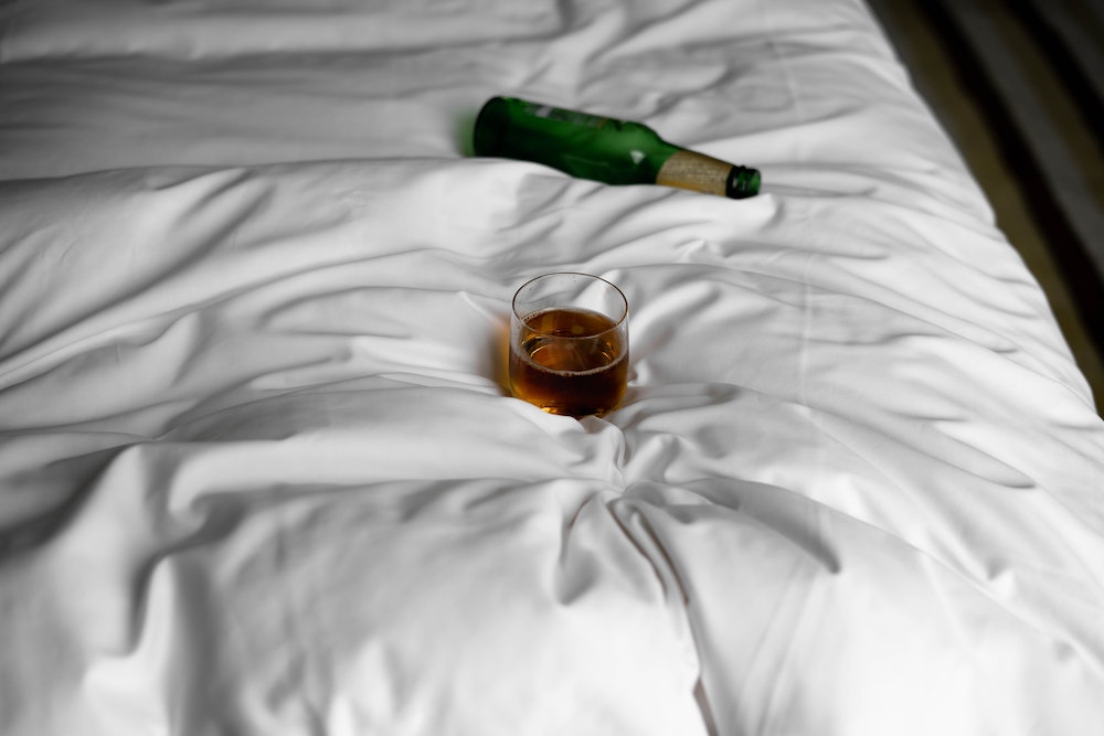 Alcohol beer whisky on a bed