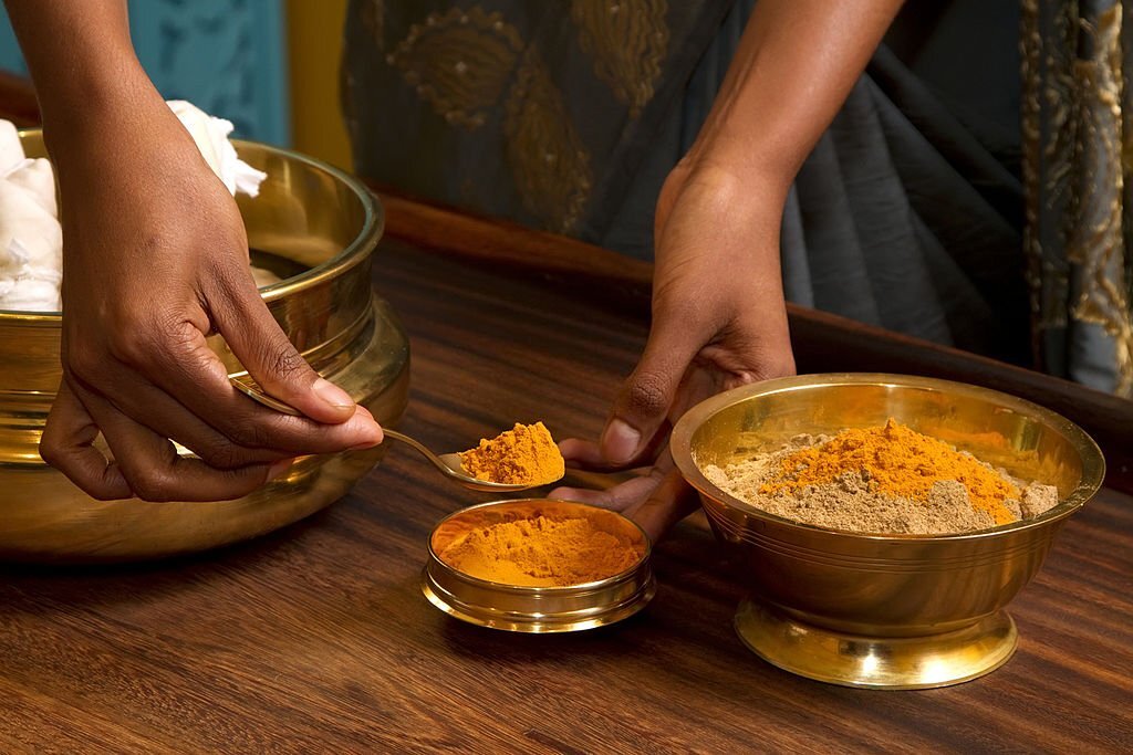 preparing herbs powder for traditional indian ayurvedic massage